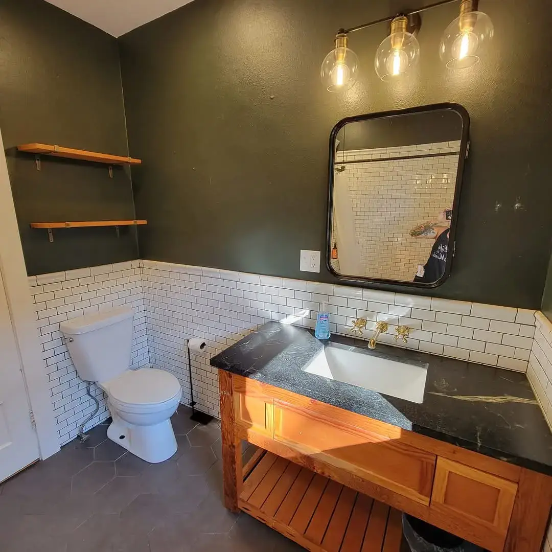 Modern bathroom with sink, mirror, and toilet.