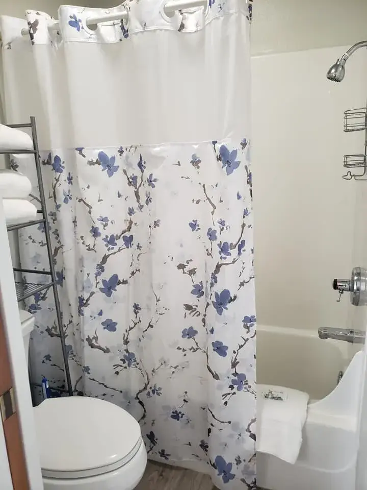 Bathroom with floral shower curtain and towels