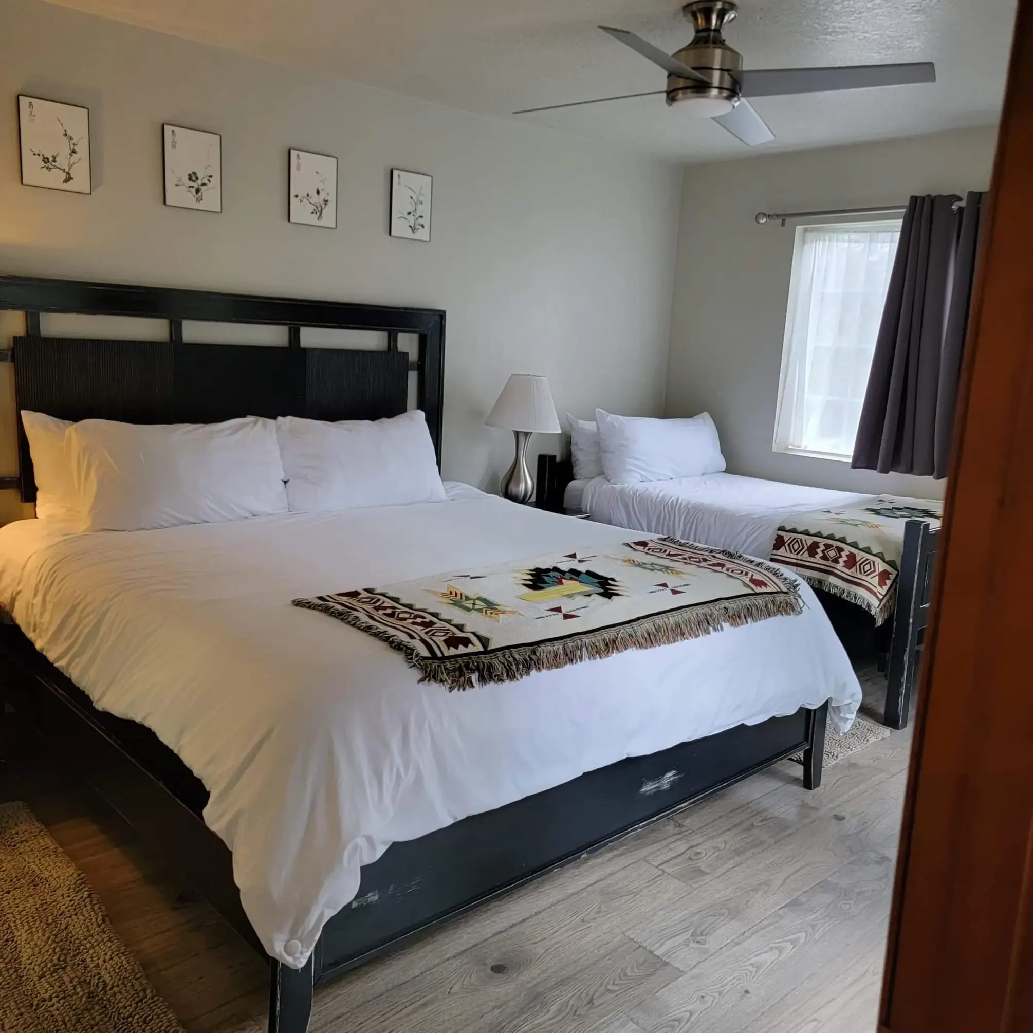 Modern bedroom with two beds and decor.