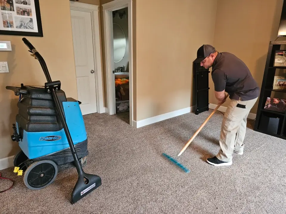 Man cleaning carpet with commercial equipment.